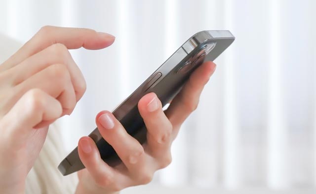 家族葬の小平市葬儀社に電話でお問合せしようとしている人の手元。